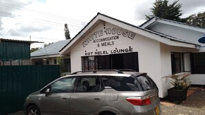 A building with a sign reading "WHITE HOUSE ACCOMMODATION & MEALS" and "KOT NEL LOUNGE". - WHITE HOUSE LOUNGE & GUEST HOUSE (Eldoret)