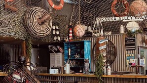 Un intérieur rustique avec un coin bar, des chaises en osier et des éléments de décoration sur le thème de la marine.