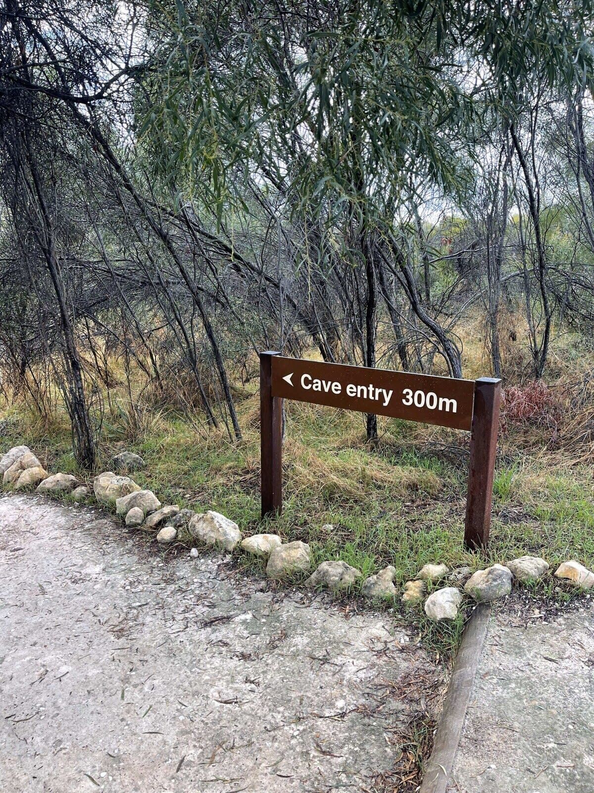 Señal que indica la dirección hacia la entrada de la cueva, a 300 metros.