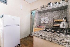 Een koelkast, een blender, kookgerei, borden en bestek, een kreeftenpan