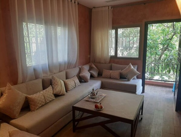 Relax in this inviting living room with a comfortable sofa, coffee table, and beautiful garden views.