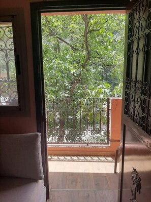Enjoy the serene view from your balcony with a large sliding glass door and a comfortable cushioned bench.