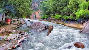A river with rocks and a building in the background. - Appartement Exceptionnel à Ourika (Marrakech)