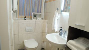 Ein Badezimmer mit Toilette, Waschbecken und Handtuchhalter.