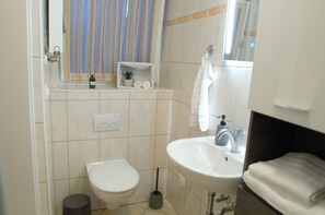 A bathroom with a toilet, sink, and a towel rack. - Gemütliche Ferienwohnung am Lüsenberg, Nahe Gelegen der Arnsberger Altstadt (Arnsberg)
