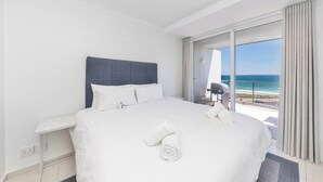 Una camera d'albergo con un letto grande, una scrivania e vista sull'oceano.