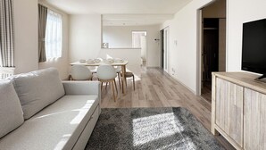 A modern, well-lit living room with a sofa, a dining table with chairs, a TV on a wooden cabinet, and a hallway leading to a bedroom. - Yutori (Onomichi)