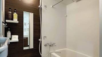 Une salle de bain moderne avec une baignoire blanche, un meuble-lavabo en bois et un miroir.