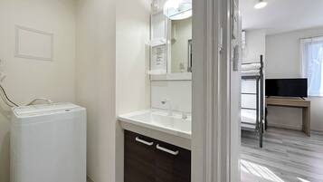 A modern bathroom with a white sink, dark wooden cabinet, and a mirror above the sink.