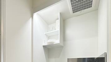 A compact kitchenette with a built-in microwave, a sink with a faucet, and a small cabinet below the counter.