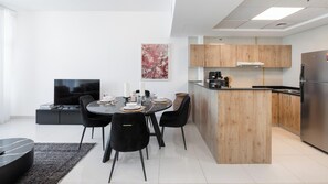 Une cuisine moderne avec des meubles en bois, un four encastré et un réfrigérateur en acier inoxydable.