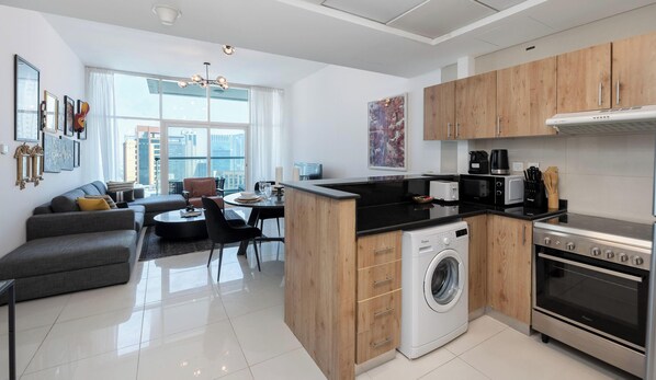 A modern apartment with a kitchen, dining area, and living room. - Premium 2BR Apt w/ Marina Views (Dubai)