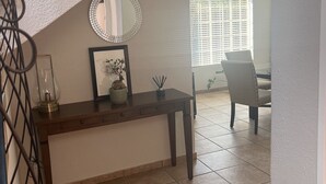 A staircase leading to a landing with a dark wooden table, a framed picture, and a potted plant. - Roodepoort Smart Home 1 (Roodepoort)
