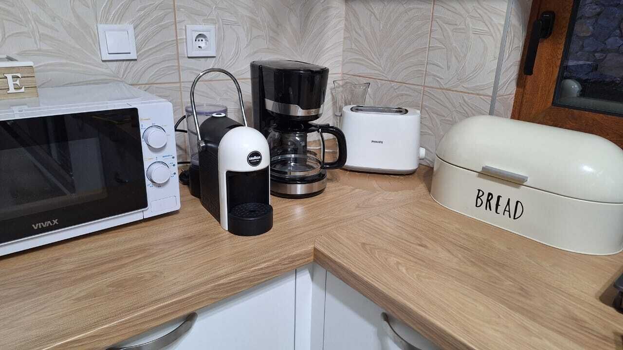 Eine Küche mit Mikrowelle, Kaffeemaschine, Toaster und einer Brotdose.