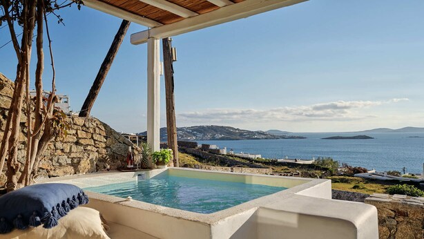 Zona de piscina con vistas al mar y a las colinas.
