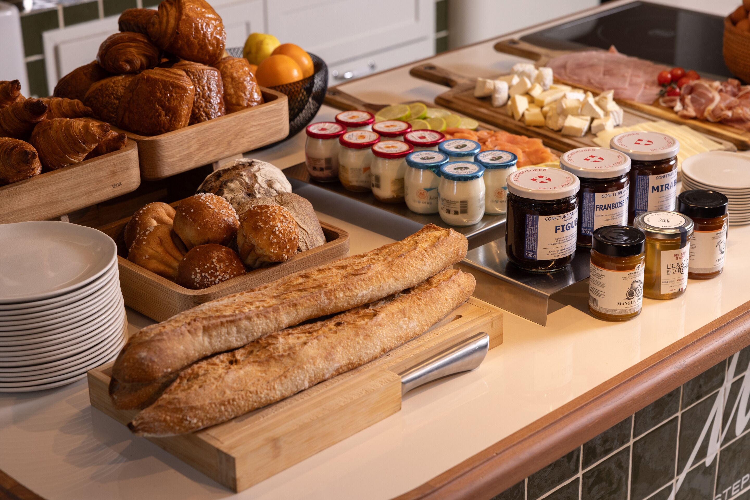 A buffet with various food items including pastries, bread, cheese, and condiments.