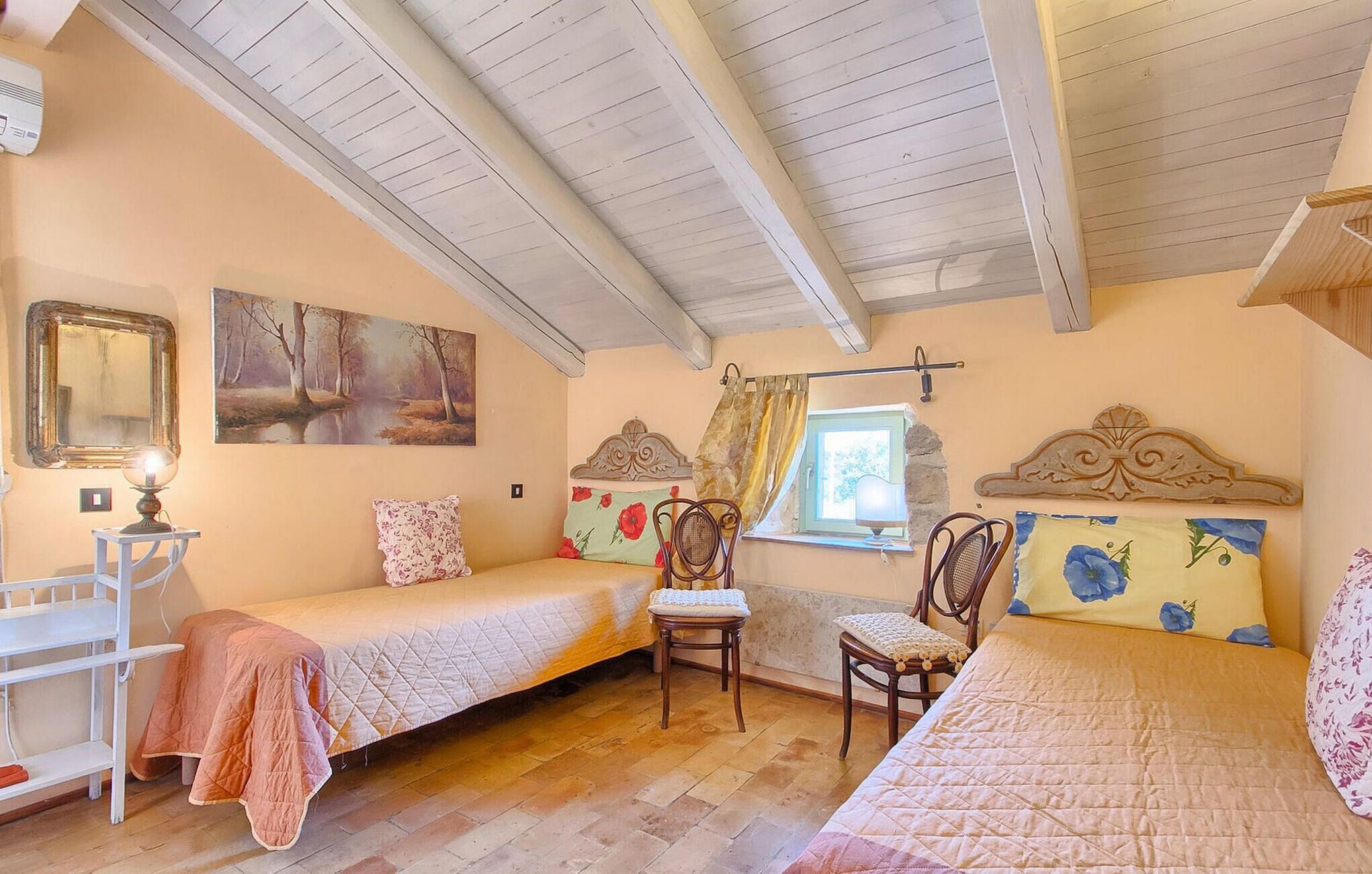 Une chambre confortable avec deux lits simples, une chaise en bois, une petite table et une fenêtre avec des rideaux.