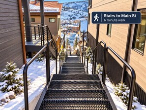 A staircase leading to Main St with a sign indicating a 6-minute walk. - Kings Crown Ski-In/Out•Private Hot Tub•Walk to Main (Park City)
