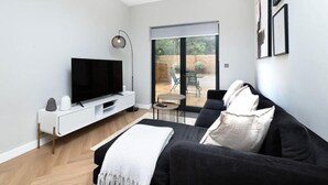 Un salon moderne avec un téléviseur à écran plat, un canapé et une table basse.
