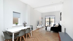 Un espace de vie moderne comprenant un coin repas, un canapé et une vue sur l’extérieur.