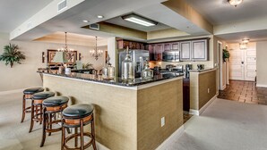 A spacious kitchen with a central island, bar stools, and modern appliances. - Seaside Elegance: Oceanfront 5BR/5BA, Sleeps 14 (North Myrtle Beach)