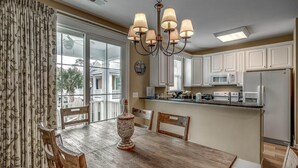 A dining area with a wooden table, chairs, and a chandelier.