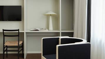 Un espacio de trabajo con escritorio, silla, estantería y lámpara.