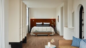 A modern hotel room with a large bed, a sofa, a small table, and a chair. - Morgan & Mees Rotterdam (Rotterdam)