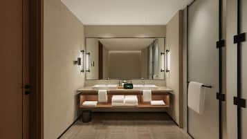 Un baño moderno con un espejo grande, dos lavamanos y un perchero para toallas.