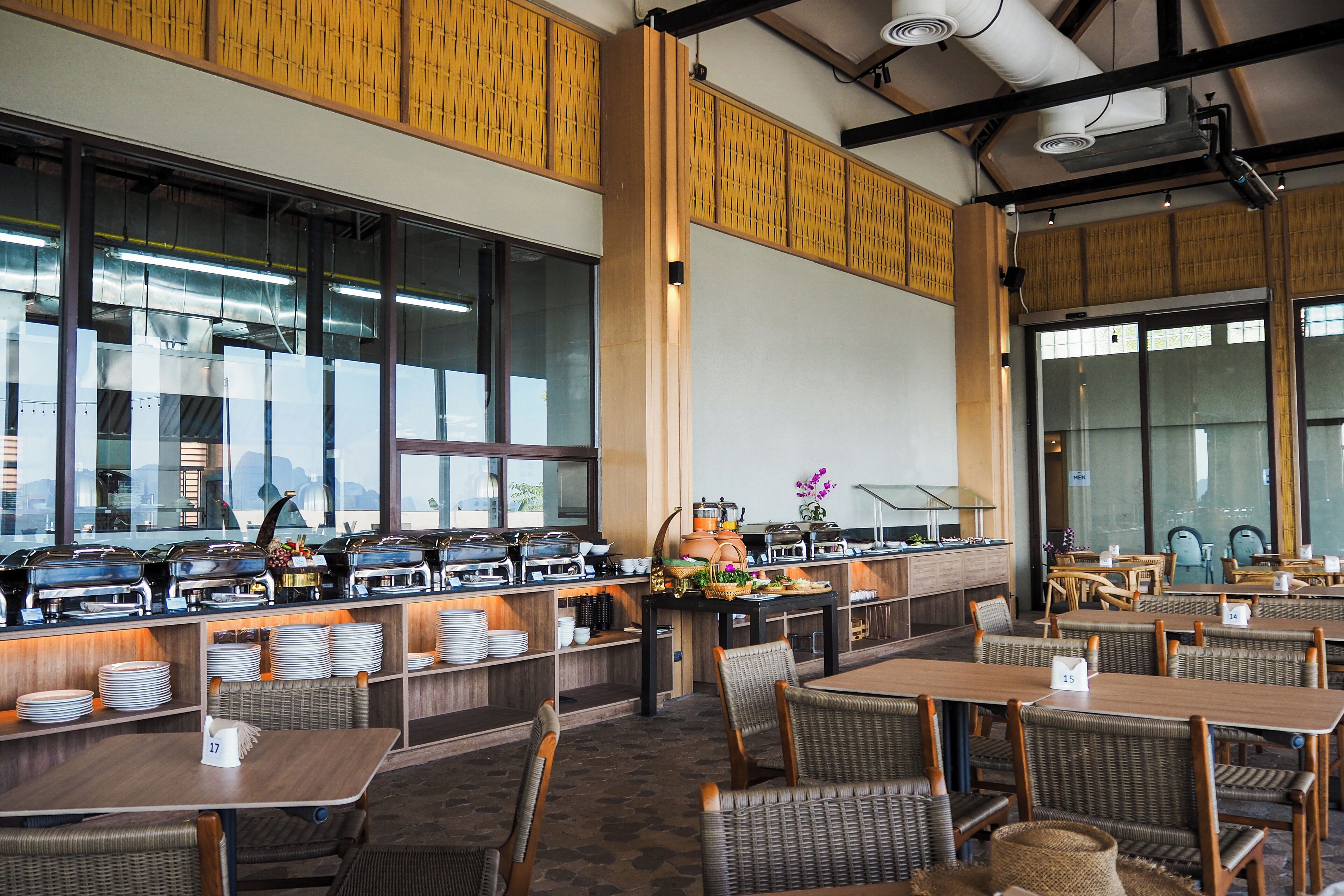 A buffet area with multiple serving stations, tables, and chairs arranged for dining.