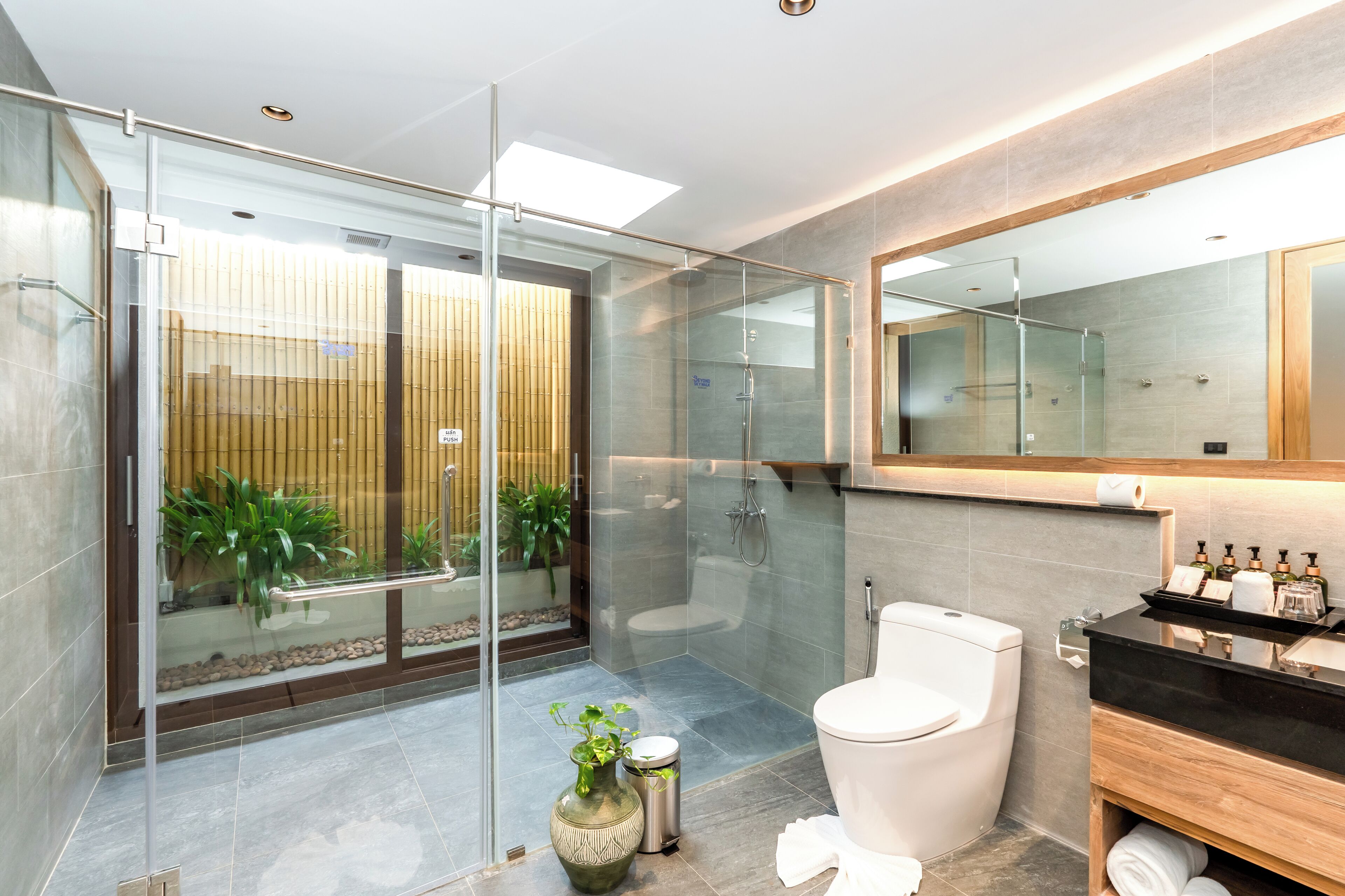 Een moderne badkamer met een douchecabine, toilet en een wastafel met toiletartikelen.