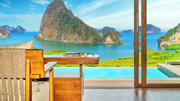 Une chambre moderne offrant une vue sur une côte montagneuse et une piscine.