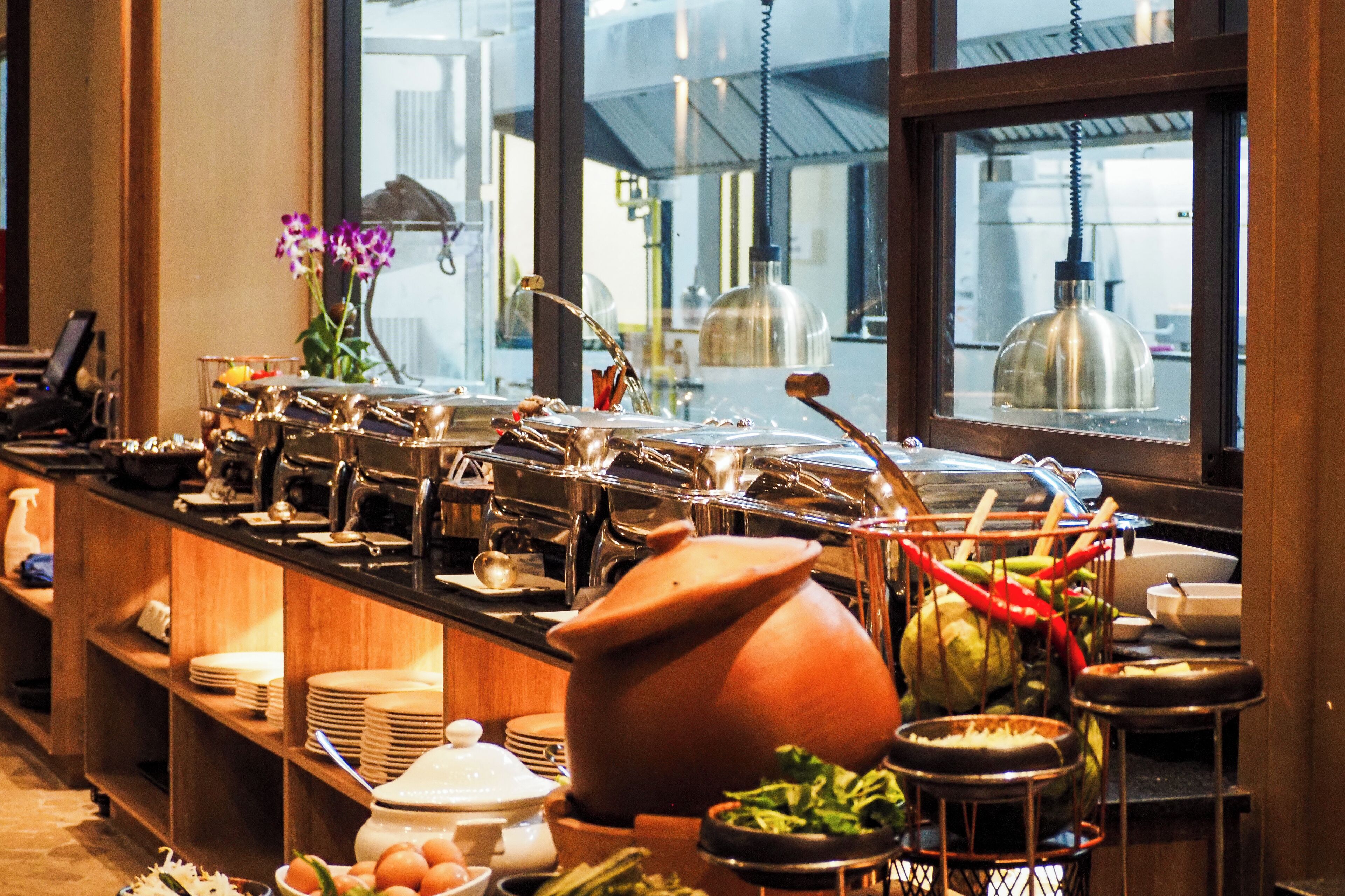 A buffet setup with various food items and utensils.