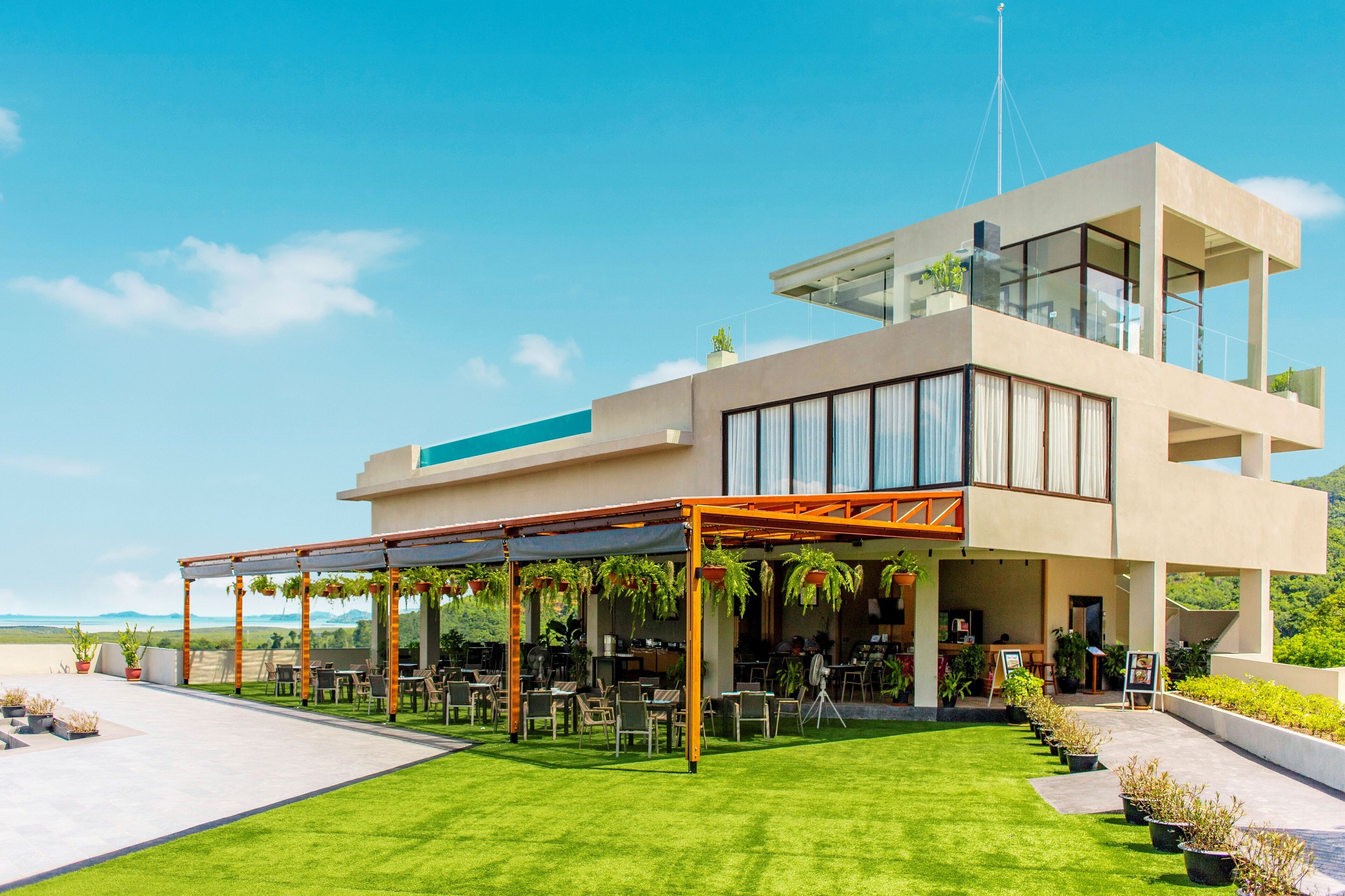 Un hôtel moderne doté d’une terrasse sur le toit, d’un espace extérieur aménagé et offrant une vue dégagée sur les environs.