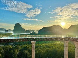A bridge with a view of a river and mountains in the background.