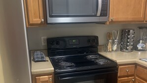 A kitchen with stainless steel appliances, including a refrigerator, microwave, stove, and oven. - Welcome Home (Charlotte)