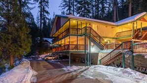 Un lodge a più piani con un balcone e una scala.