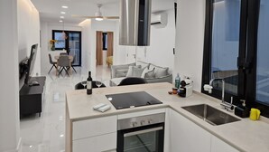 Uma cozinha moderna com uma ilha central, forno embutido e uma janela ampla.