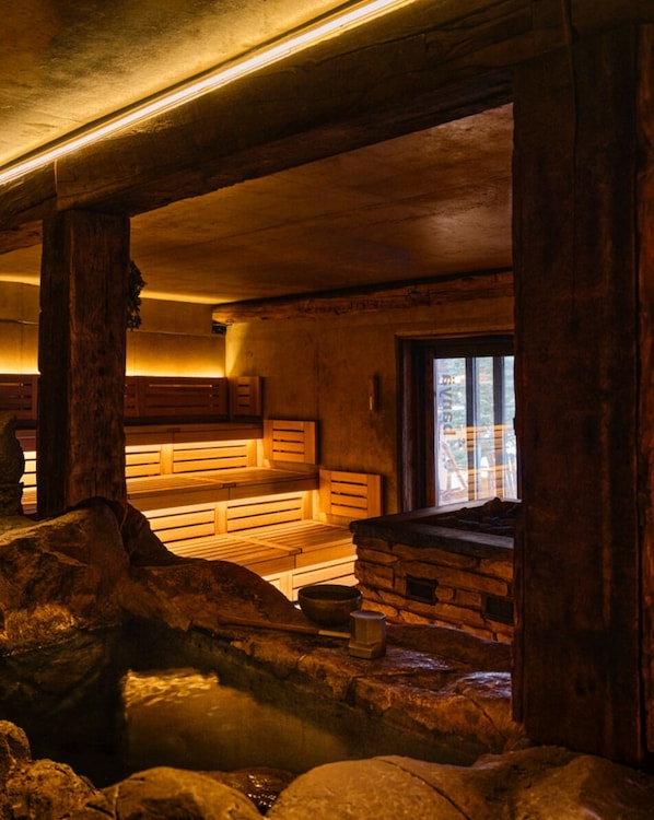 A rustic interior with wooden benches, a stone wall, and a window. - 5 Star Apartment (Gatineau)