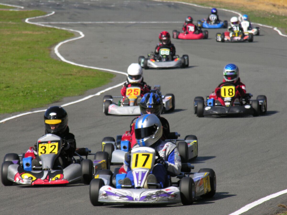 Een kartbaan met meerdere karts en bestuurders.