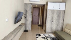 A hallway with a coat rack, a sofa, and a wardrobe. - SleepRest @ NTC (Batam)