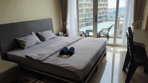 A hotel room with a bed, a small table, and a chair. - SleepRest @ NTC (Batam)