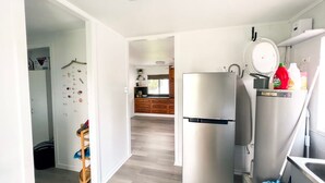 A modern kitchen with a refrigerator, sink, and wooden cabinets. - Bella Luna Beach Front 2 bed (South Mission Beach)