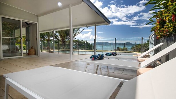A modern outdoor lounge area with a pool, glass doors, and a view of the ocean. - Tide Pool Ocean Front 2 bed (South Mission Beach)
