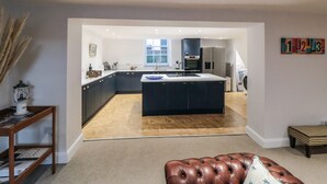 A modern kitchen with dark cabinetry, a central island, and a large window.