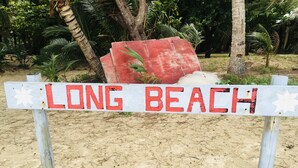 Un panneau sur la plage avec l’inscription « LONG BEACH ».
