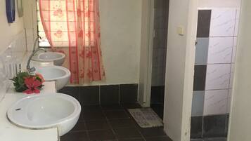 A bathroom with two sinks, a shower curtain, and a tiled floor.