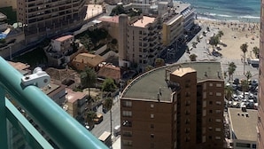 Un paysage urbain côtier avec de hauts immeubles, une plage et un ciel bleu dégagé.