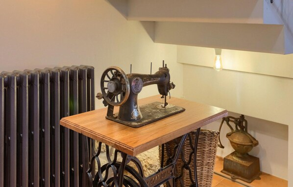 A vintage sewing machine on a wooden table in a room with a radiator and a lamp. - Awesome home in Opatija (Opatija)