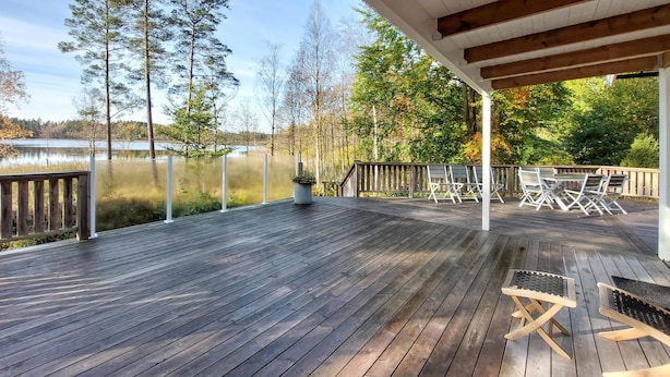 A wooden deck with a view of a lake, surrounded by trees and a gazebo. - 3 bedroom awesome home in örkelljunga (Örkelljunga)